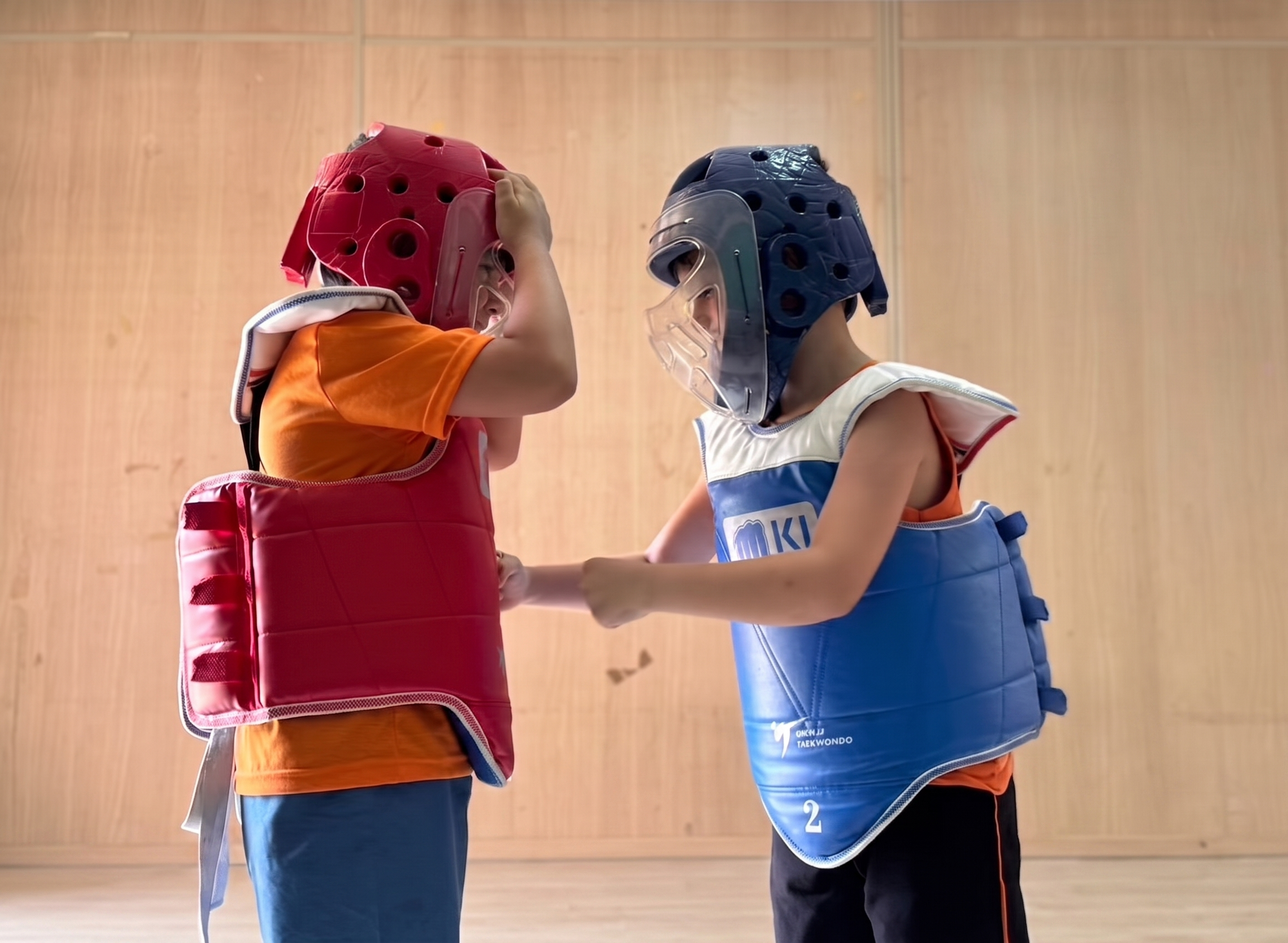 Crianças em aula de Taekwondo com equipamentos de proteção