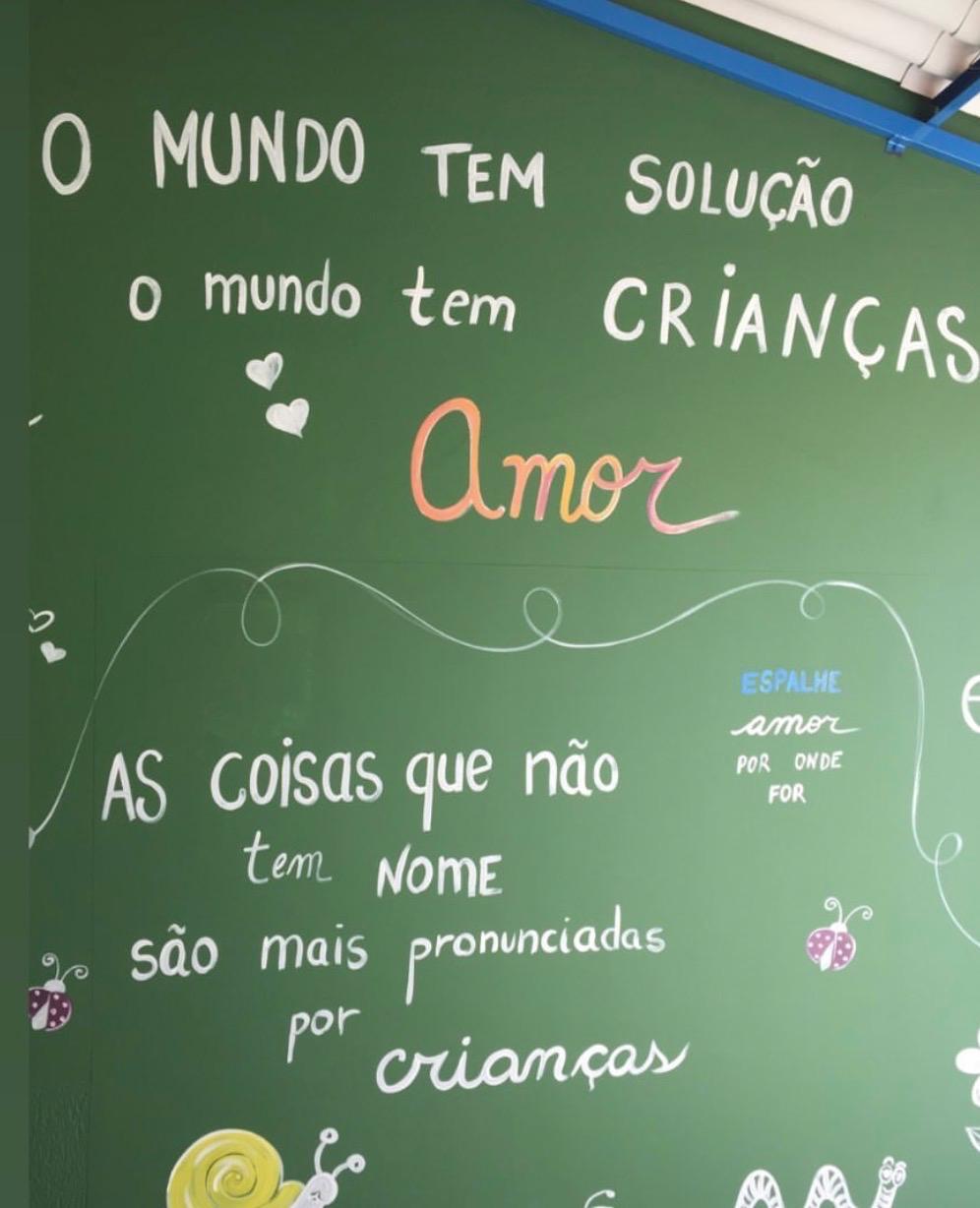Mural verde com frase sobre amor e crianças