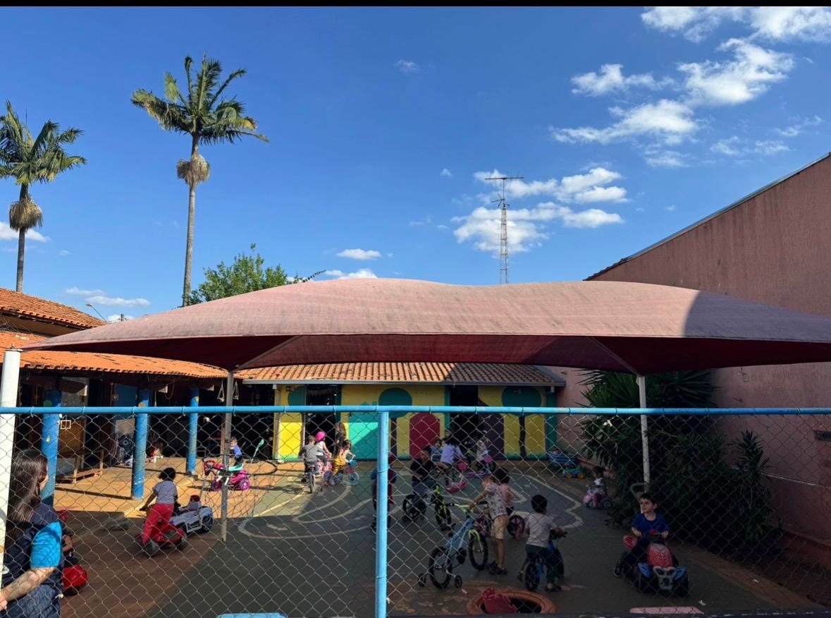 Pátio externo com crianças brincando de bicicleta